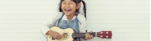 young Asian girl playing ukulele
