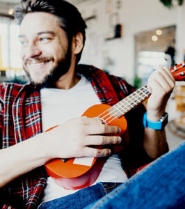 adult man playing ukulele