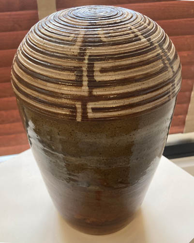 Ceramic image of a vessel with a basket designed lid