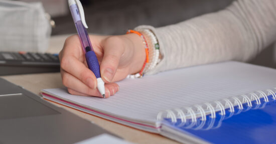 person writing in notebook