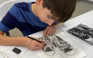 a boy drawing a pair of shoes