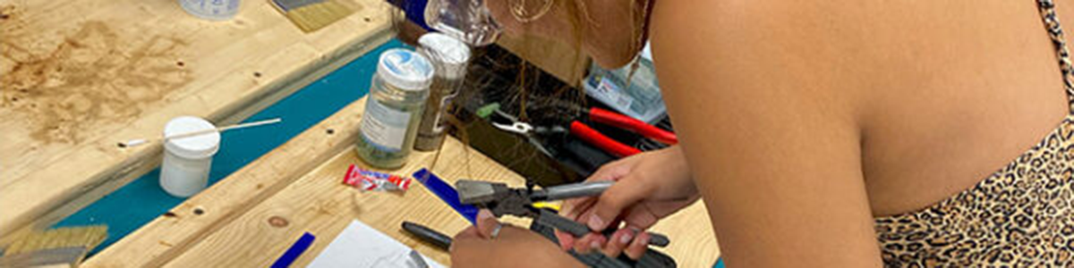 young woman working on a fused glass project in the glass arts studio