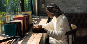 young African American woman writing in her journal at a desk