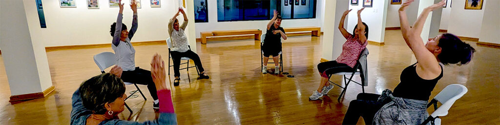 Participants with their arms high in our art gallery during class