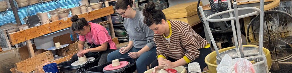 pottery students working on the wheel
