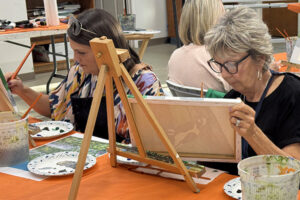 women painting in a classroom