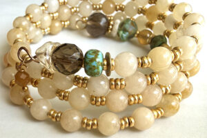 beautiful beaded handmade wire wrap bracelet in white with accents of brown and green beads